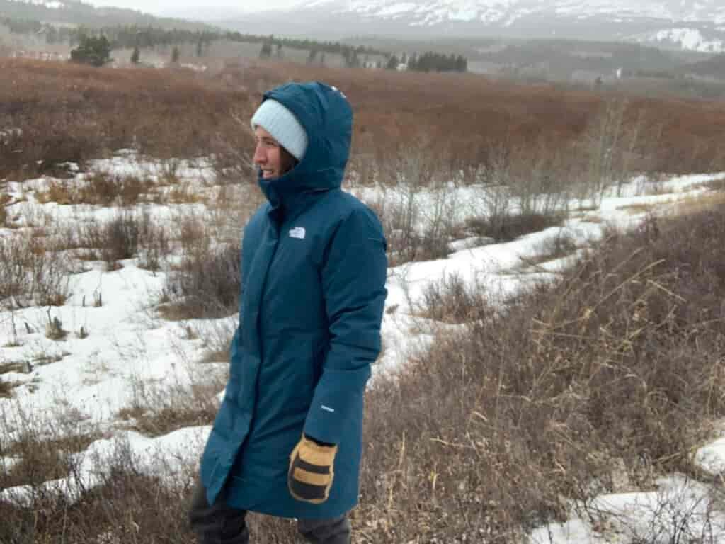 a woman wearing the north face arctic on a walk in the snow and wind