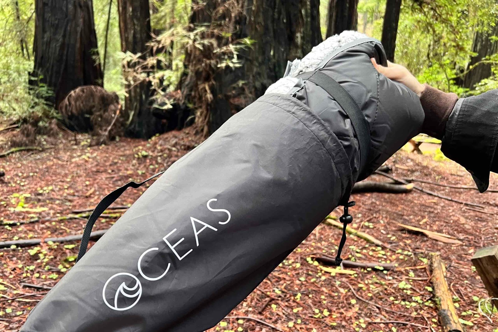 Close-up as someone pulls the Oceas Sherpa Fleece Blanket out of its carry bag.