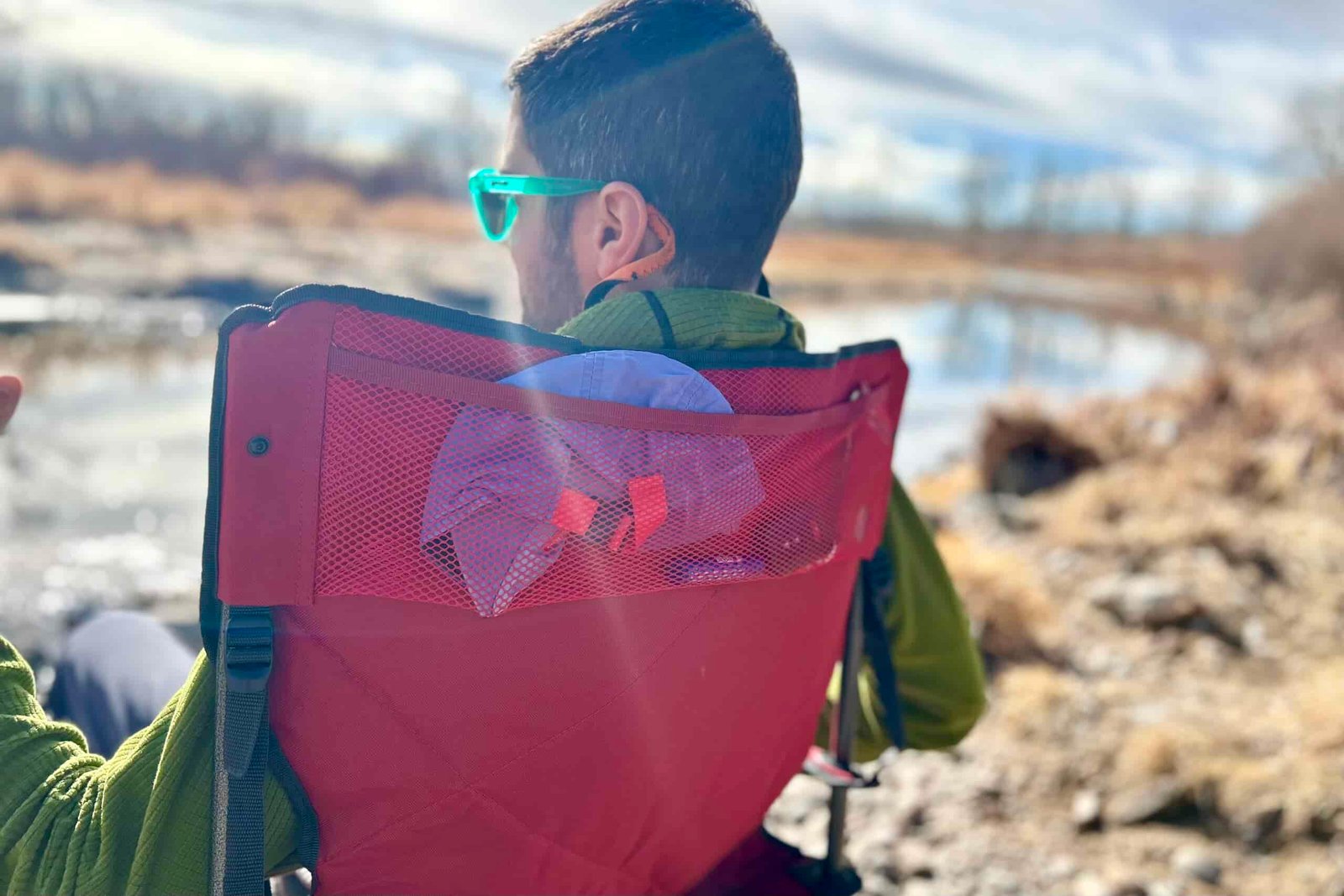 Close up of the back of a man's head and the back of a camping chair.