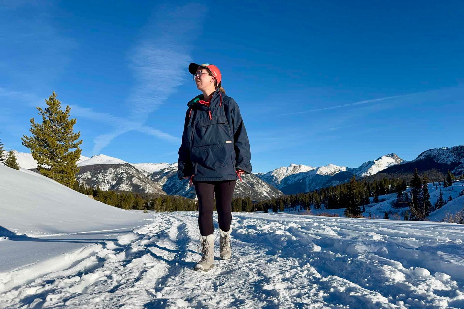 A person wearing the Ice Maiden boots is walking in the snow with some mountains in the background.