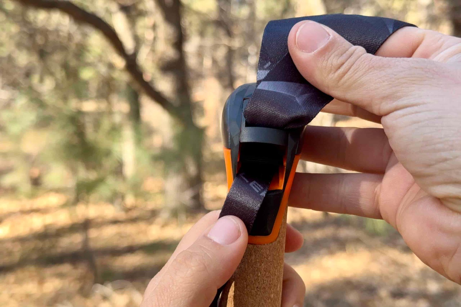 A close up of the Leki Air Grip wrist strap tightening system with a forest in the background.