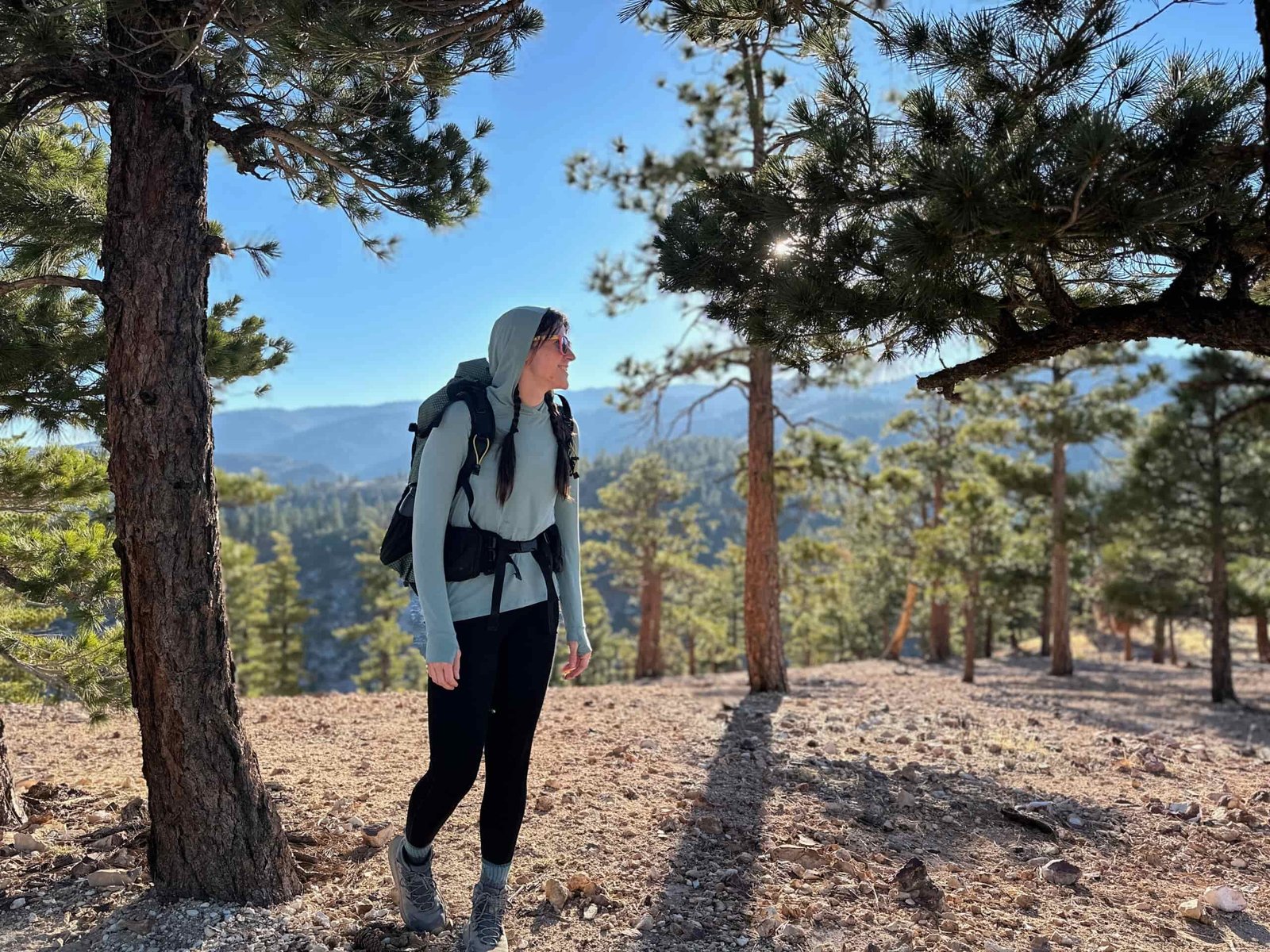 woman hiking with backpacking pack on in pine forest