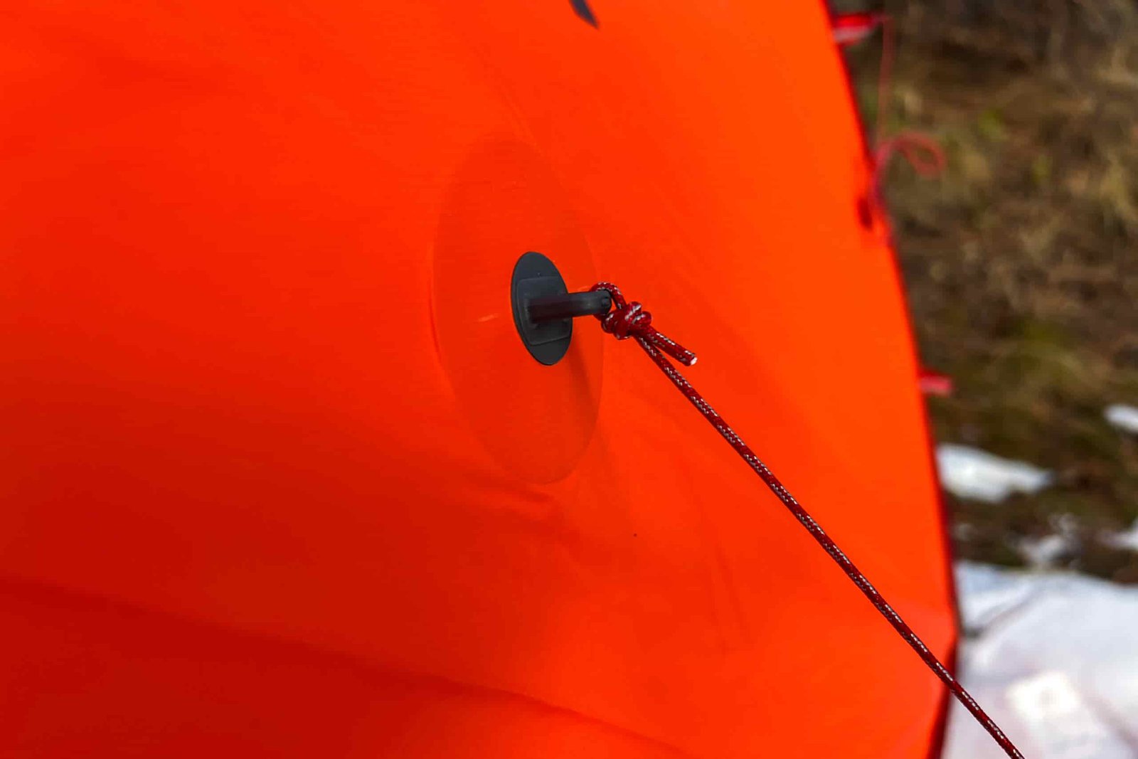 A detailed view of the MSR Advance Pro 2 tent’s guyline attachment, featuring reinforced fabric and a secure cord.
