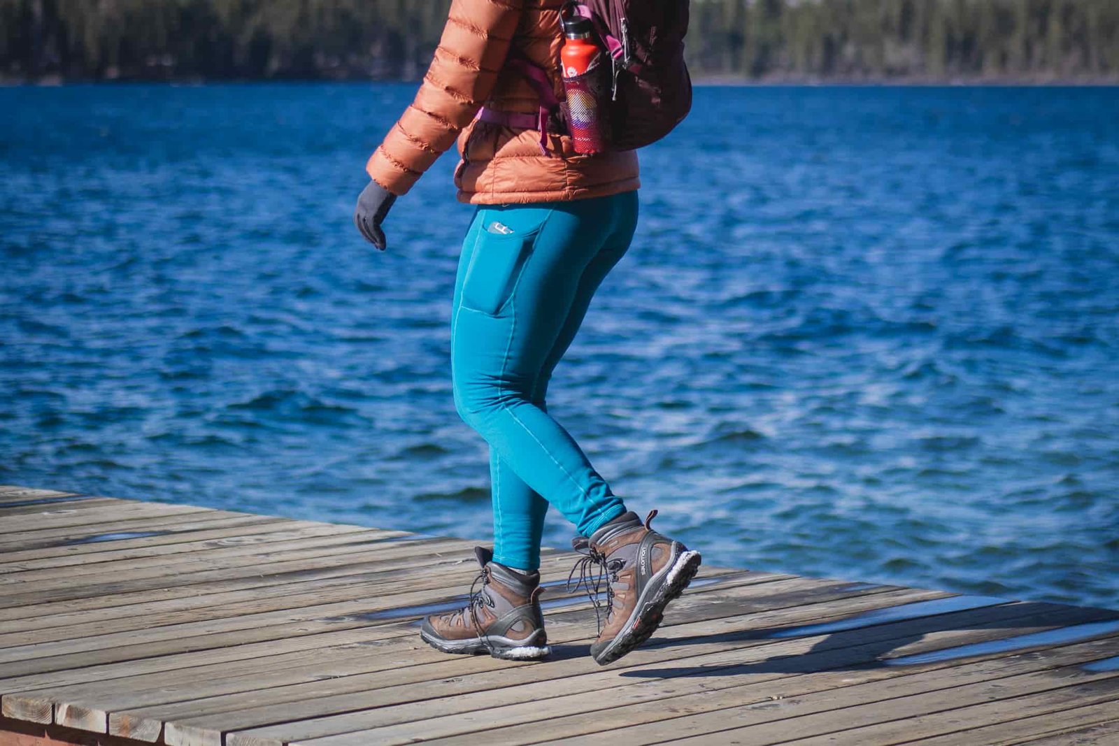Woman hiking in bright blue leggings.