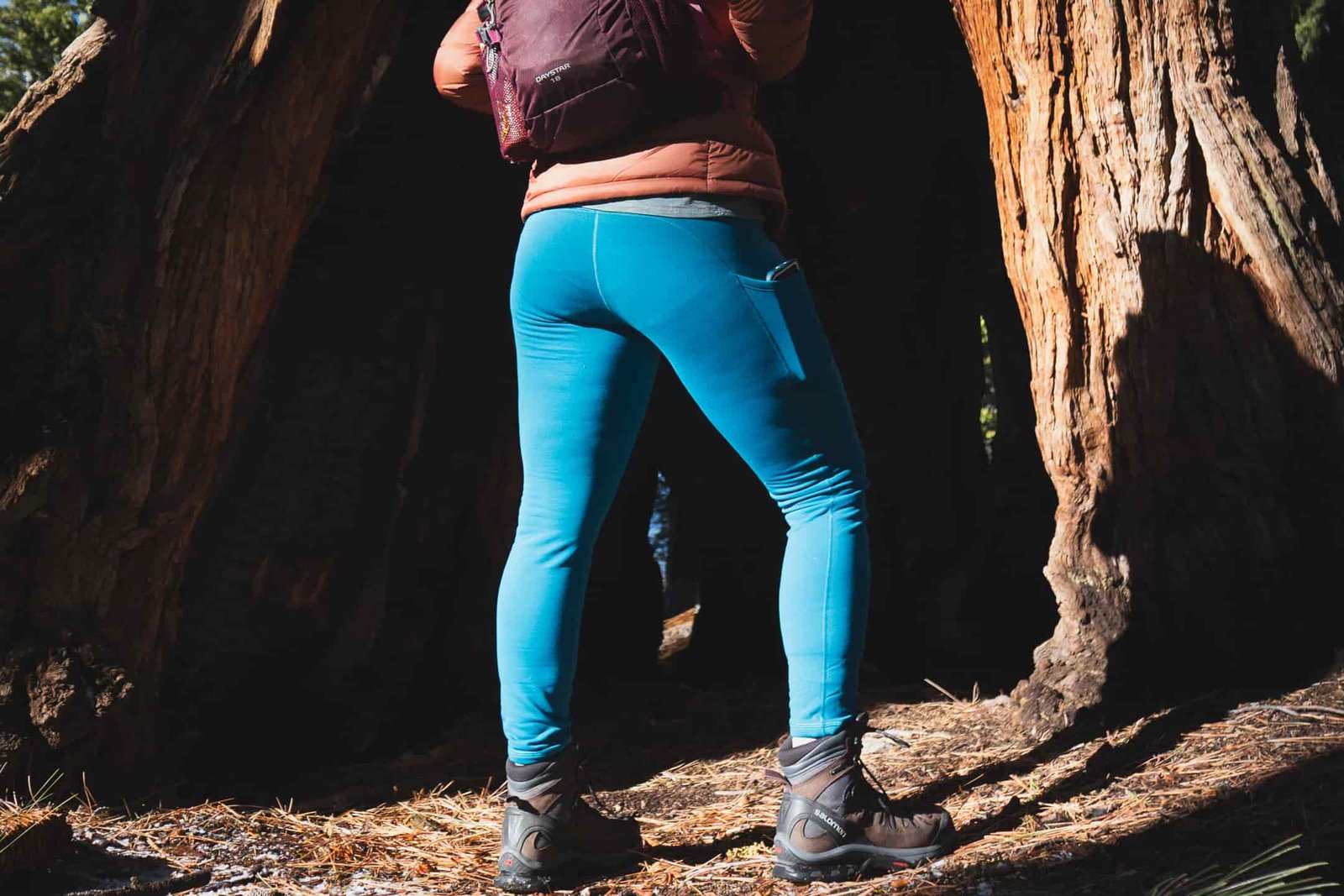 Woman hiking in bright blue leggings.