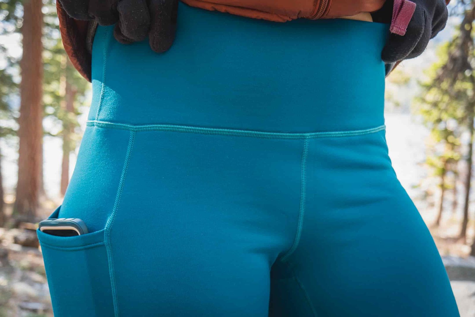 Woman hiking in bright blue leggings.