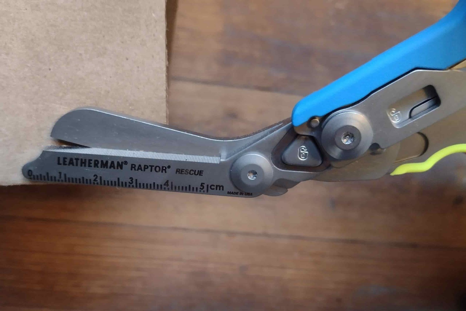 The Leatherman Raptor's ruler, engraved on its shears, measuring a sheet of cardboard.