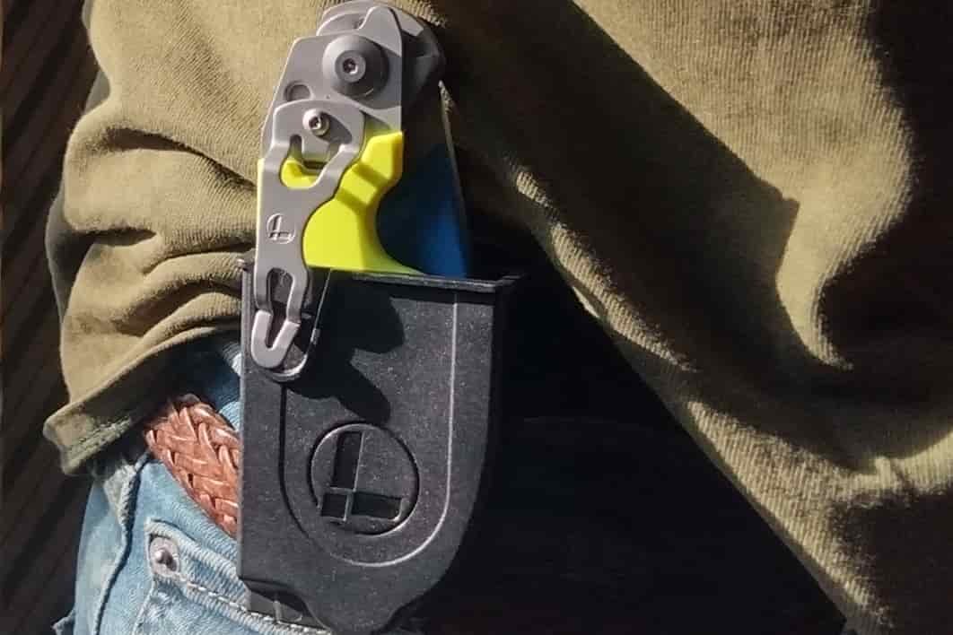 The Leatherman Raptor in its black holster clipped to a belt.