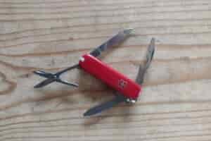 The Victorinox Rambler, resting on a board, with its tools deployed.