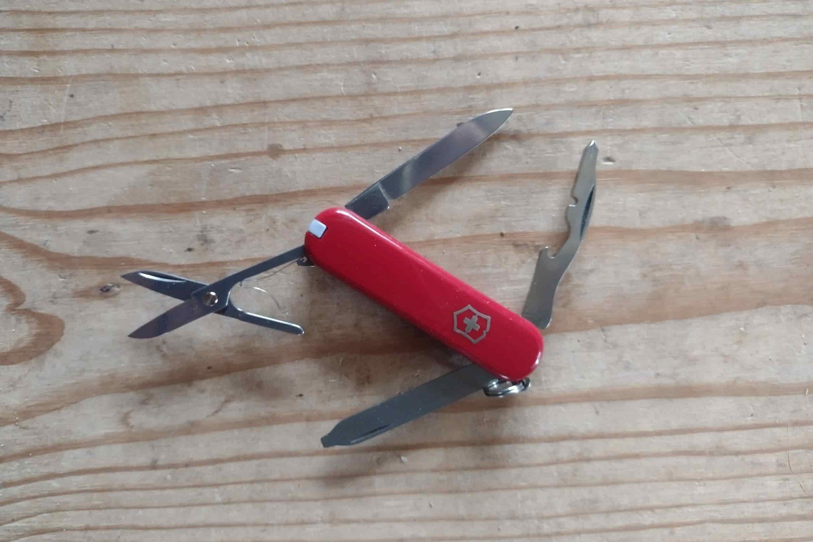 The Victorinox Rambler, resting on a board, with its tools deployed.