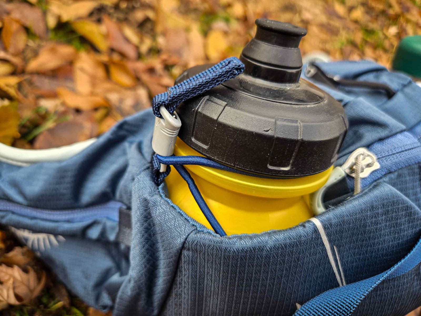 a close up of a water bottle secured to the osprey tempest 6 liter waist pack