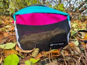 the front of the atom packs fanny pack called the roo on the ground with the mesh pocket stuffed