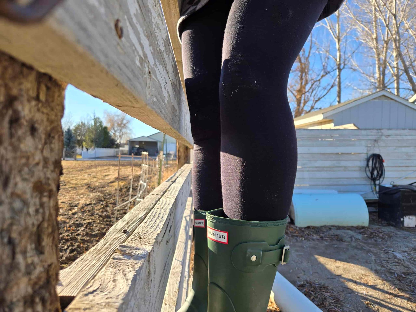 women on a fence in hunter orginial boots