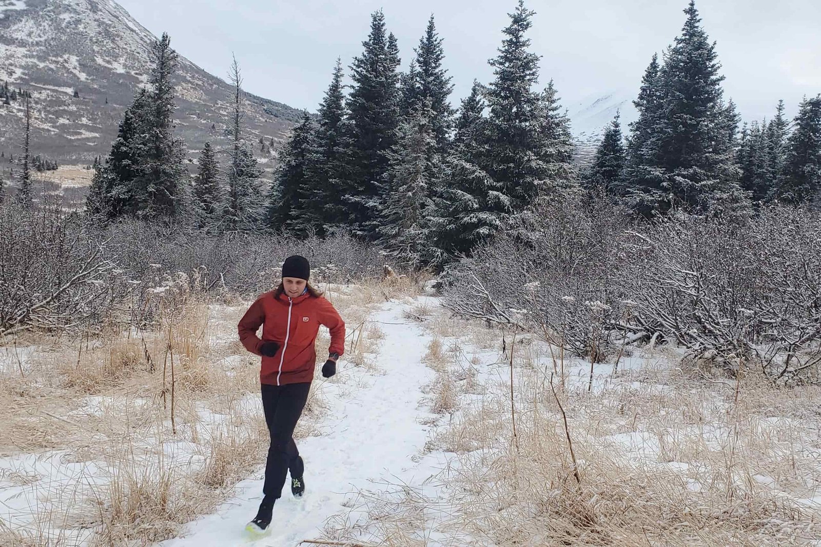 A man runs through a snowy forest.