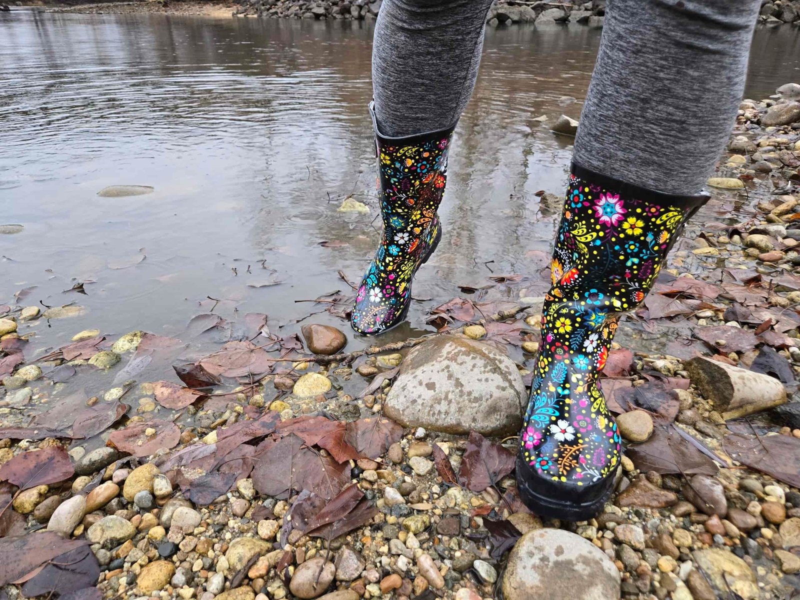 a person walking on the edge of a pond in the western chief garden play rain boots