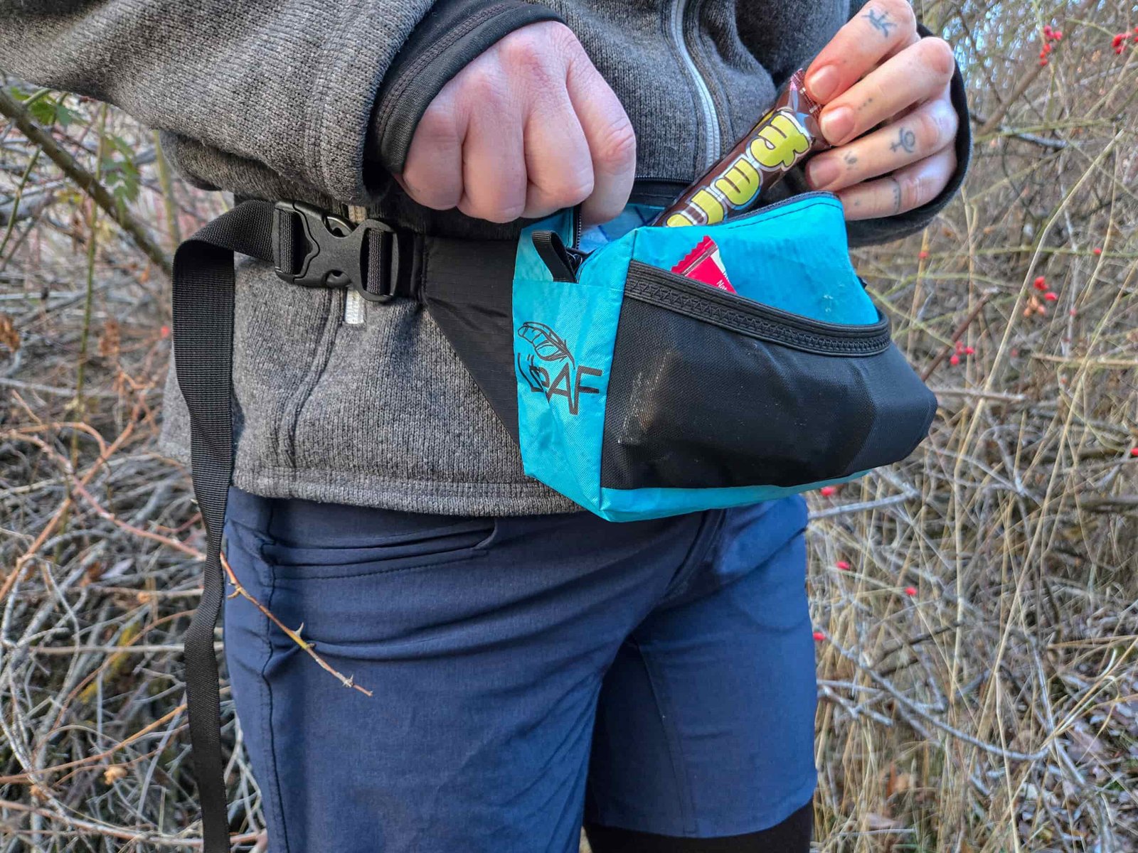 pulling a snack out of the liteaf featherweight fanny pack