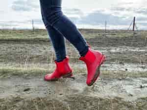 woman on a farm walking in mud in ankle rain boots by asgard