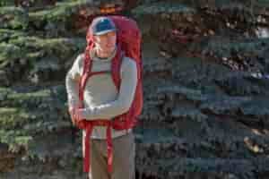 a man wears a red backpack