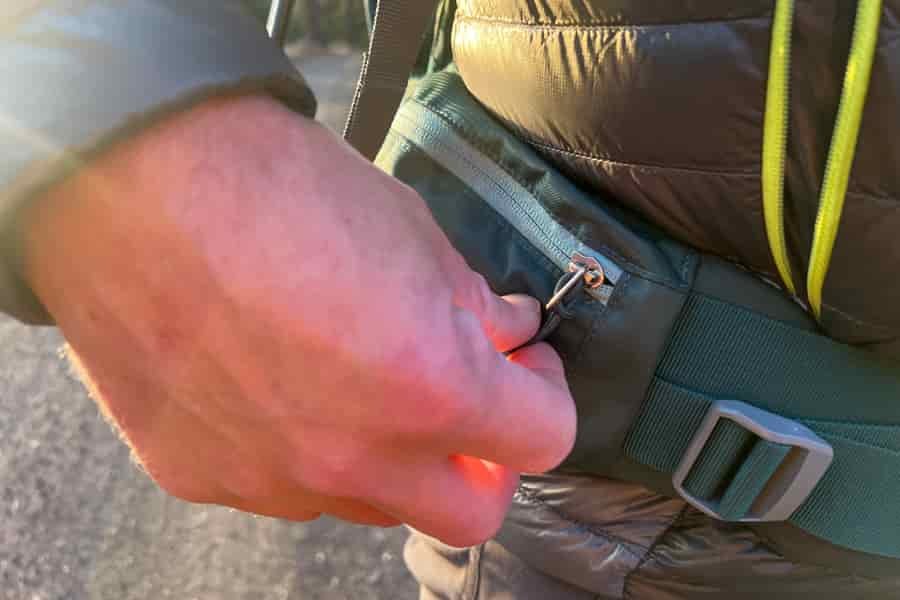 A detailed shot of a zippered pocket on the waist belt of the Deuter Kid Comfort carrier, showing its convenient storage feature.
