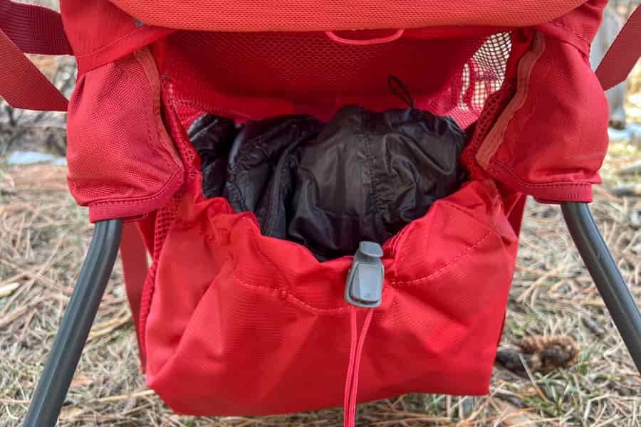 a sweater in the bottom compartment of a deuter backpack sitting on a grassy surface