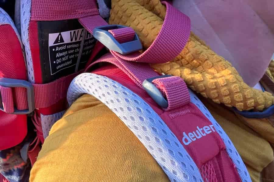 a close up of the load lifters of a red backpack