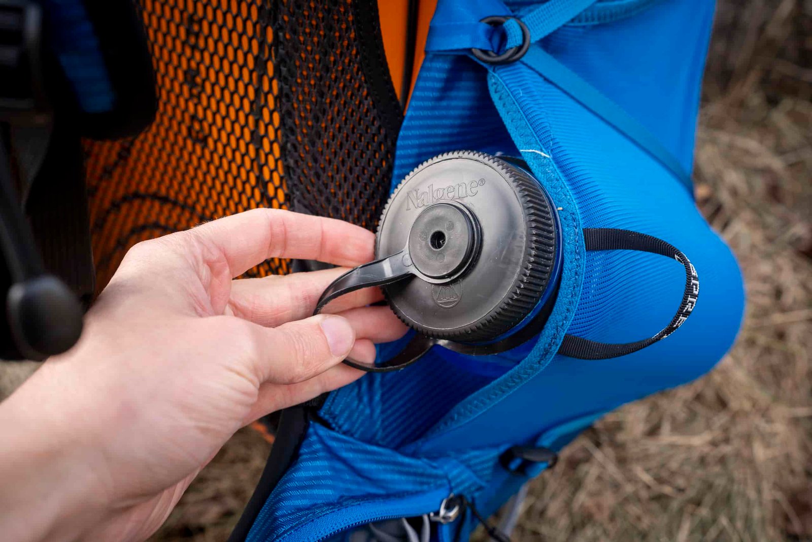 a hand holds a water bottle in a side pocket