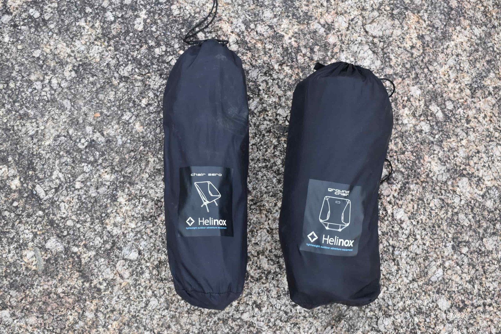 Two packed backpacking chairs side by side on a rock