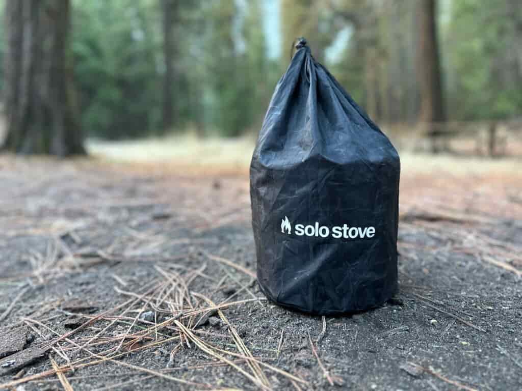 showing off how the Solo Stove Campfire packs down, first within its own contained pot, then into a convenient draw-string bag.