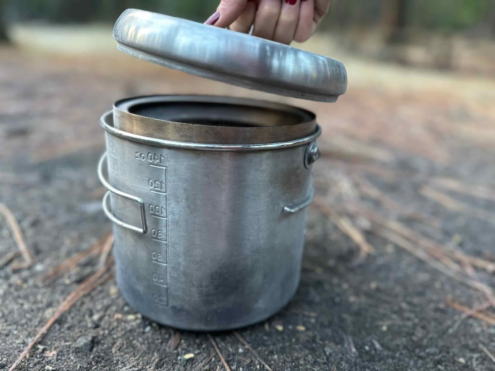 showing off how the Solo Stove Campfire packs down, first within its own contained pot, then into a convenient draw-string bag.