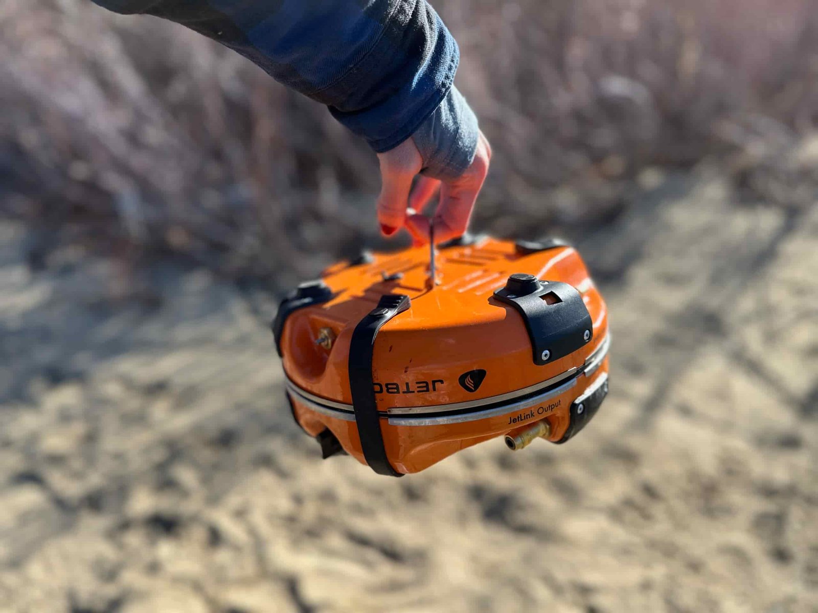 showing off how the Jetboil Genesis Basecamp System folds into itself and carries well with handles on both sides.