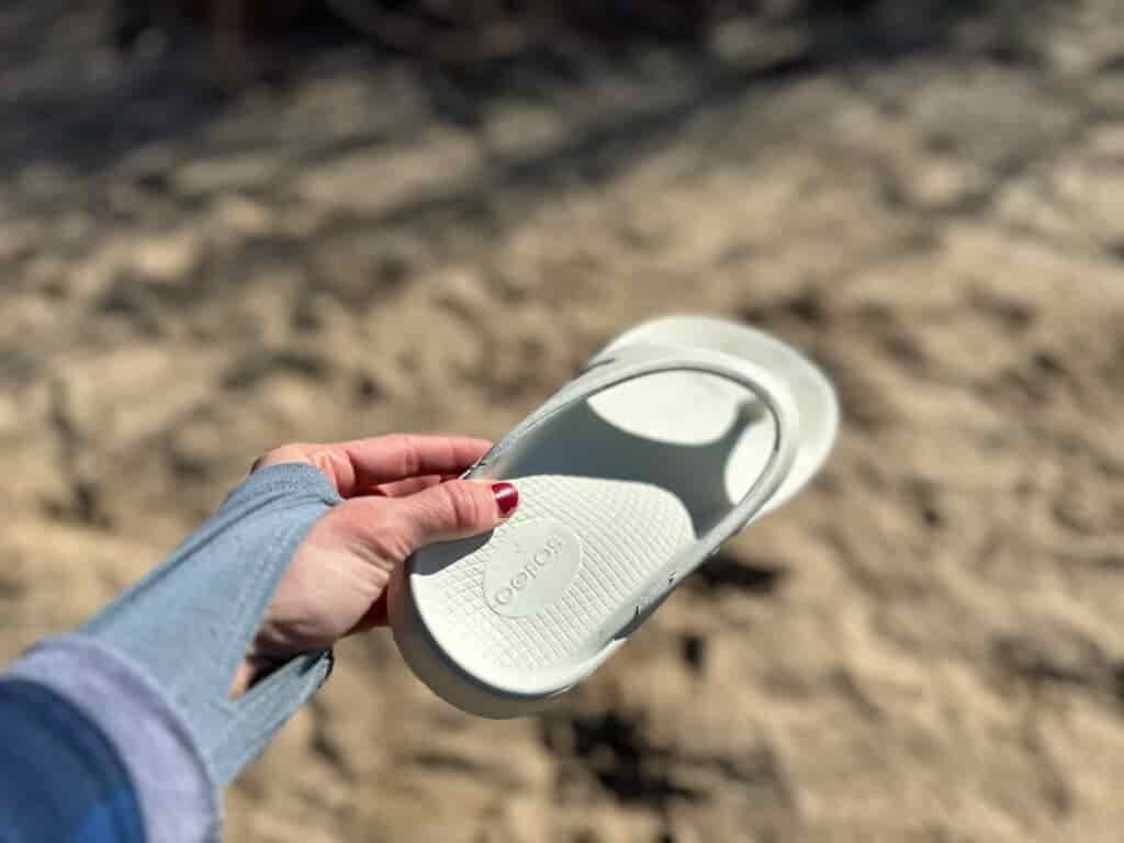 the OOfos OOriginals held up to show off the foam material of the shoe