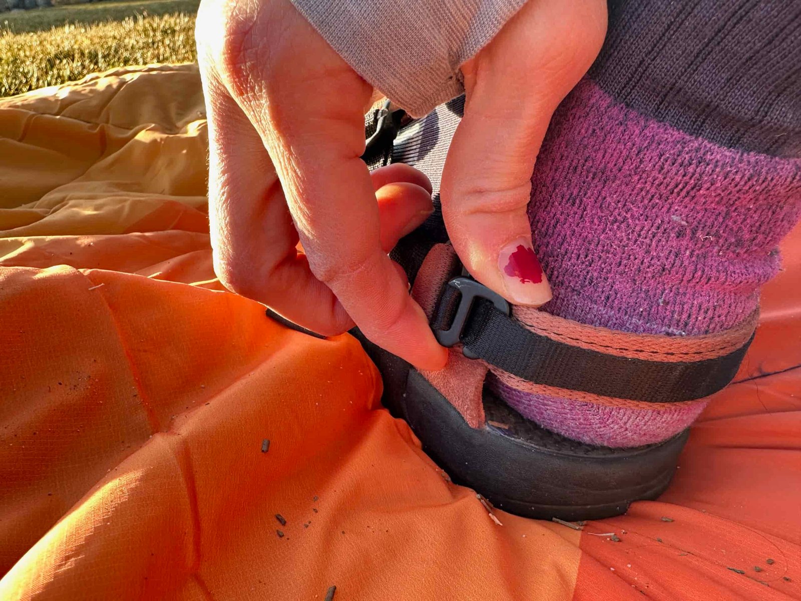 a woman shows off the adjustable straps on the Bedrock Mountain Clog
