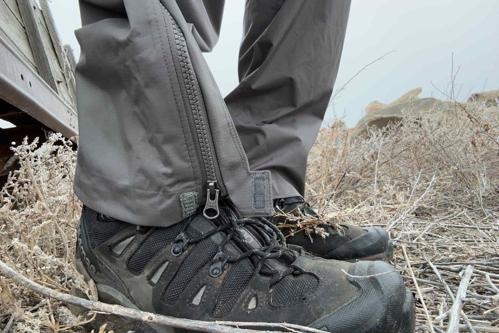Closeup of the zipper and ankle area of the REI Rainier rain pants on boots.