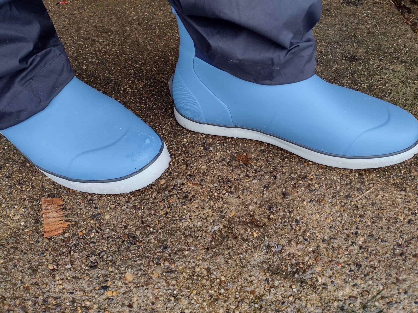 A ground level view of someone wearing the light blue Huk Rogue Wave boot.