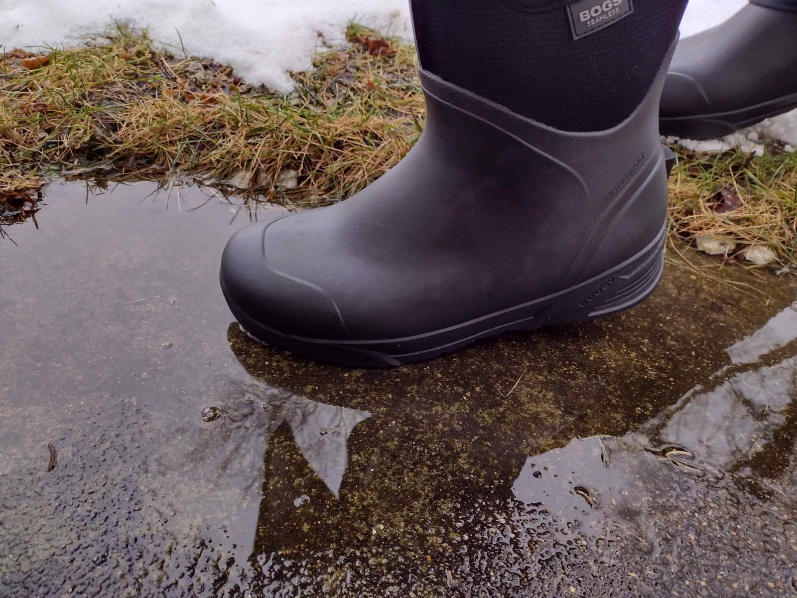 Ground level view of someone wearing the black Bozeman Mid boots.