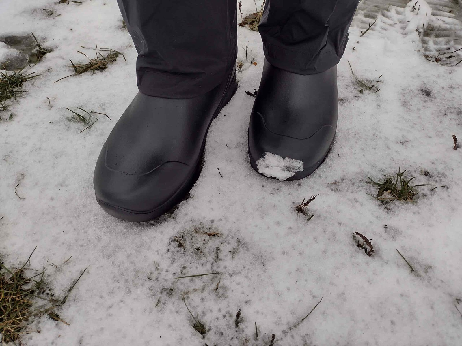 Ground level view of someone wearing the black Bozeman Mid boots.