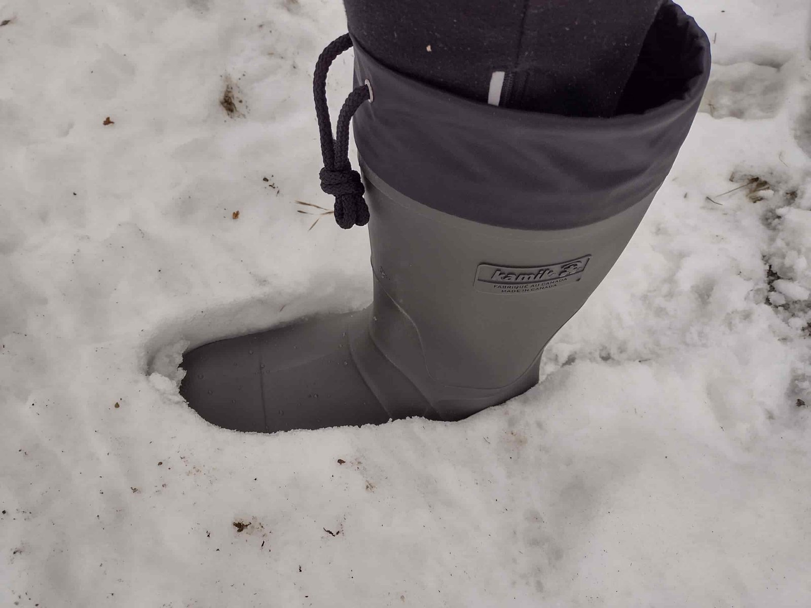 Ground level view of someone wearing the green Kamik Forester in deep snow.