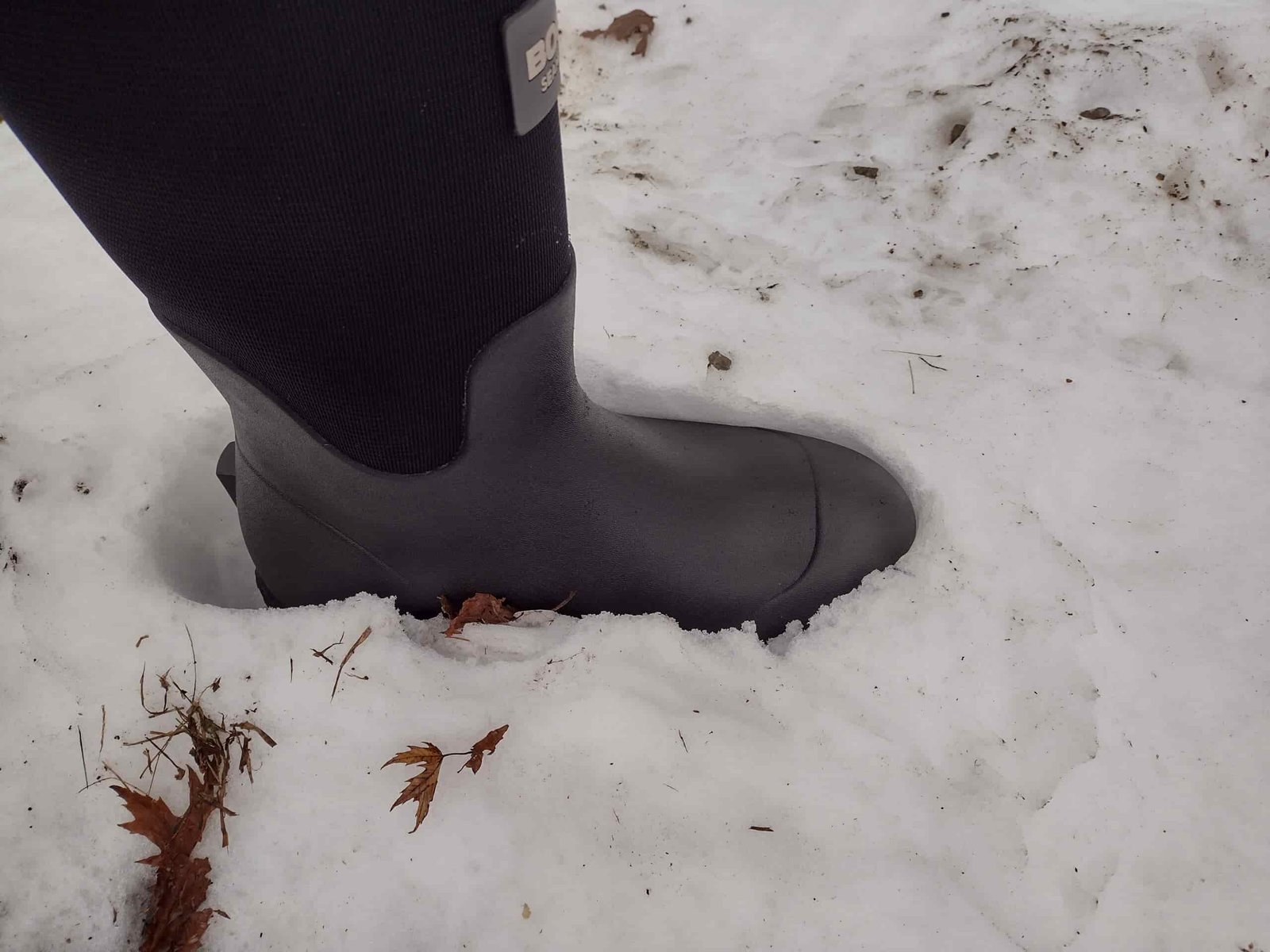 Ground level view of someone wearing the black Bogs Workman in snow.