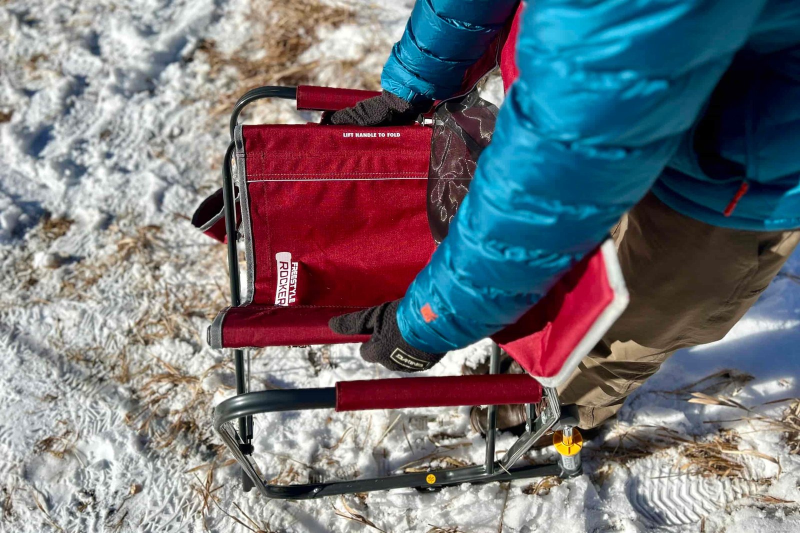 Top-down view of a person collapsing a camping chair.