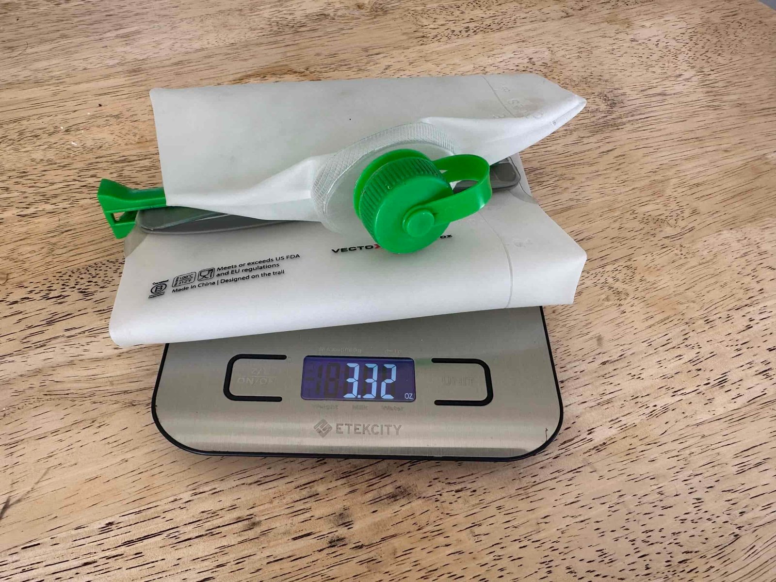 Close up image of the CNOC VectoX water container on a scale on a table. The scale reads 3.32 oz.