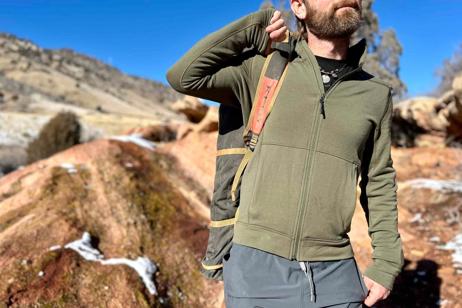 A man uses the shoulder strap of a camping chair to carry it over his shoulder.