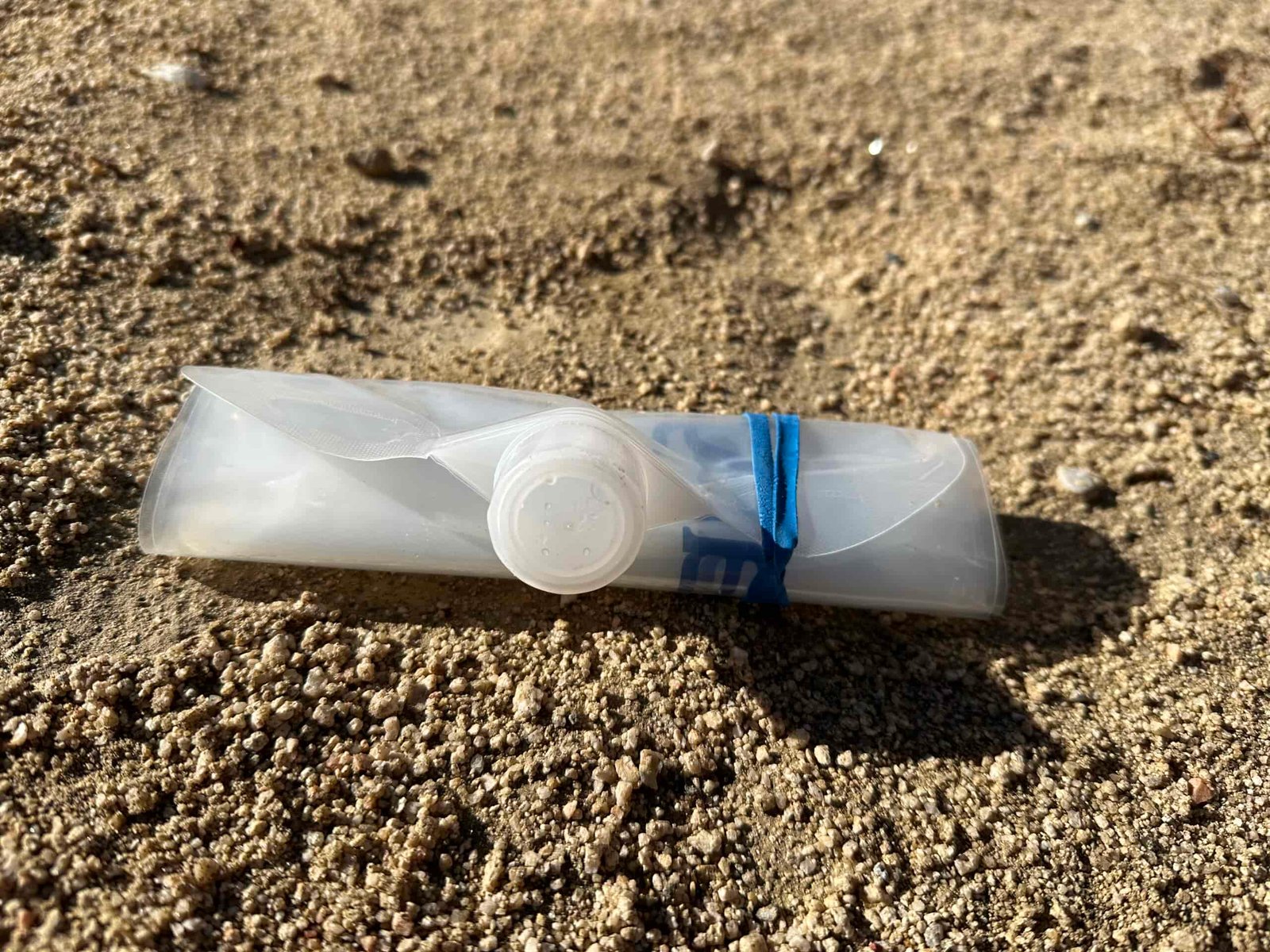 Close up photo of the Platypus Platy emptied out, rolled up, and secured in a small package with a rubber band