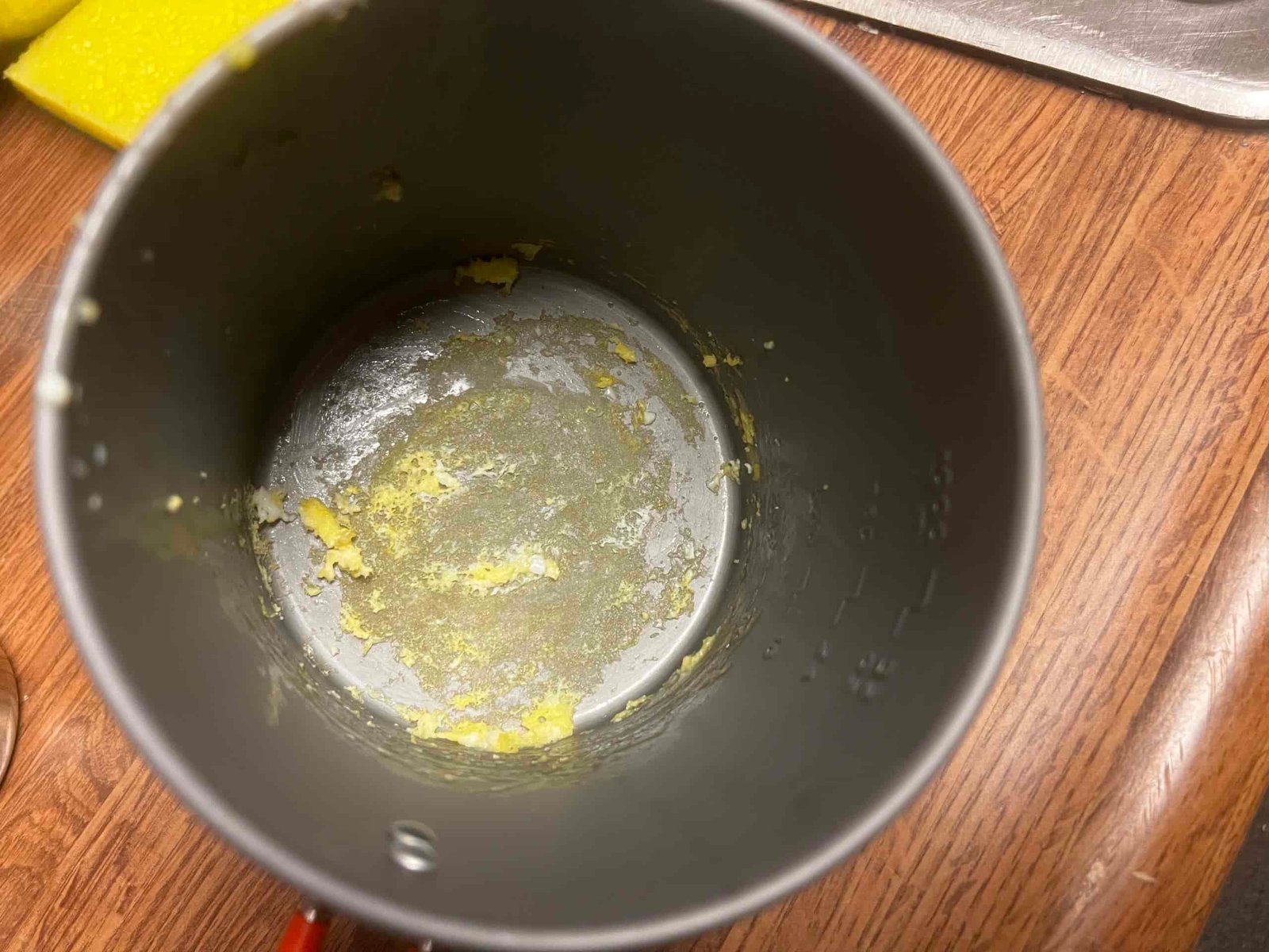 A top down view of a pot with burned egg on the bottom.