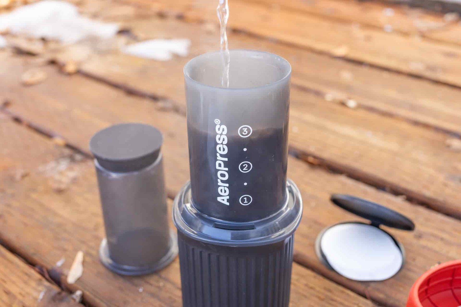 Pouring water over coffee grounds in an Aeropress Go.