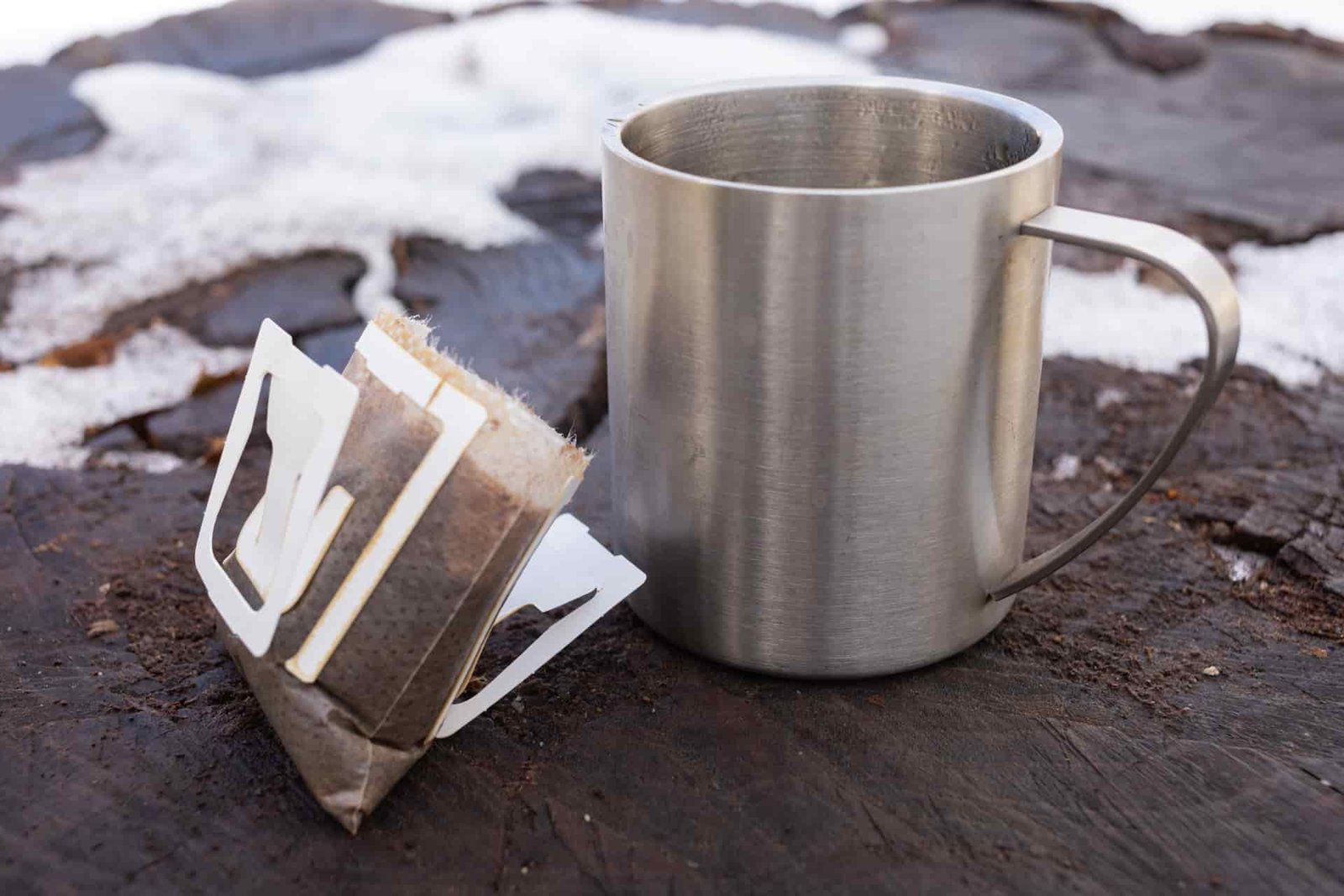 A Kuju coffee pouch next to a mug.