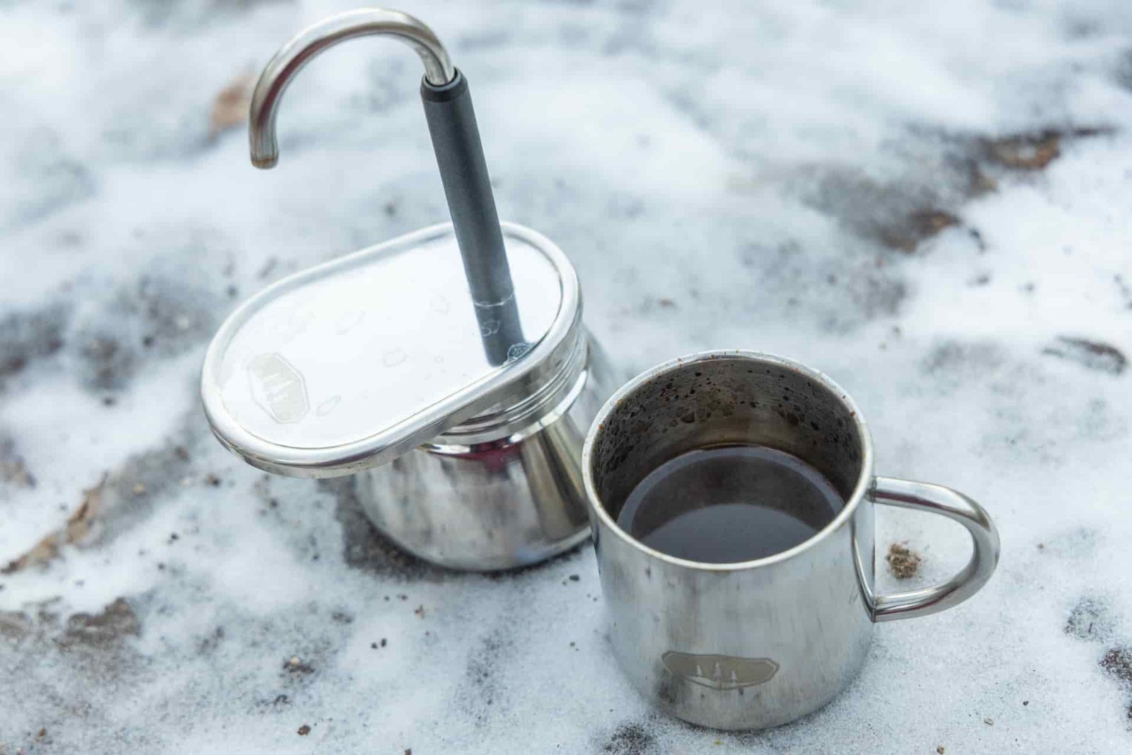 A small cup full of coffee from next to the GSI Mini Espresso.