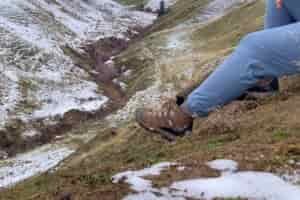 Hiker sitting on a hillside wearing the Women’s Oboz Bridger WP boots