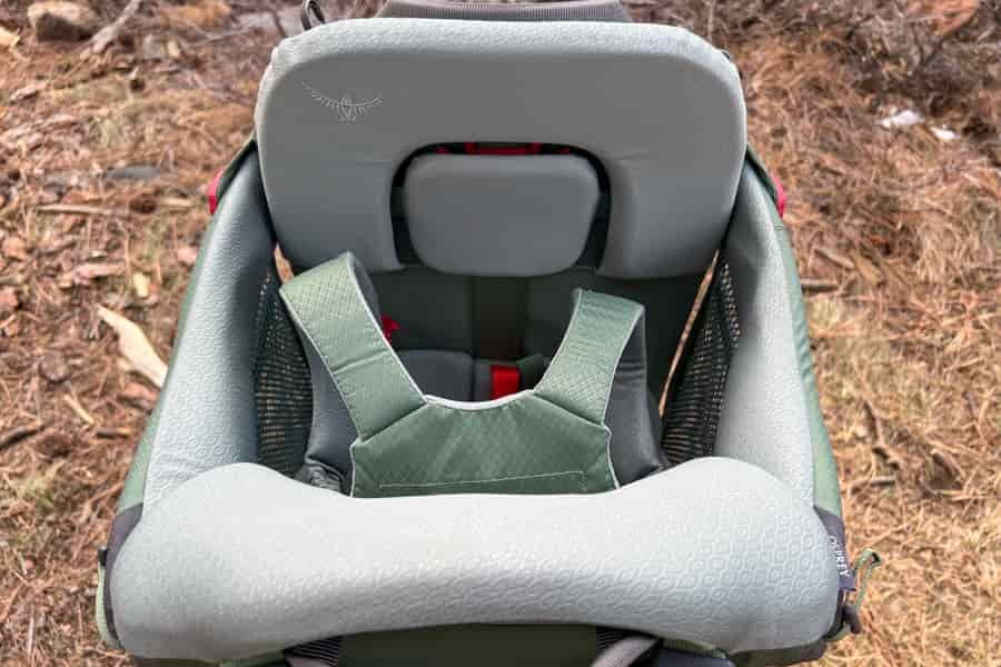 A close-up of the child seating area in the Osprey Poco Premium, highlighting the comfortable padding and secure harness system.