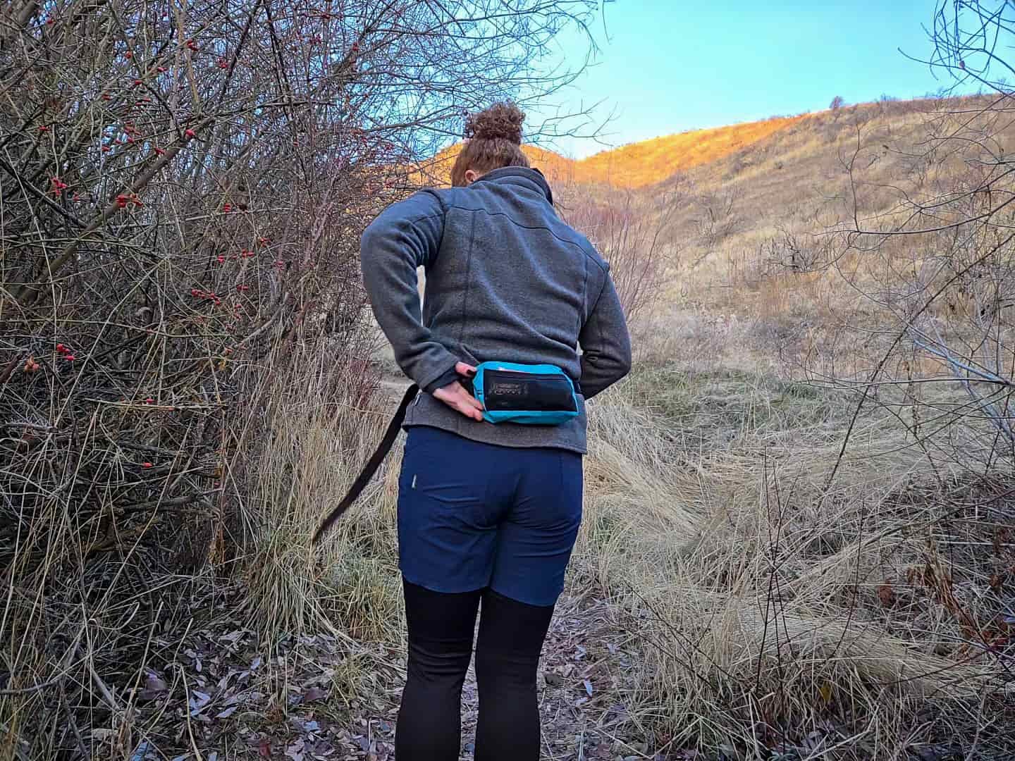 a woman adjusting the location of her liteaf featherweight fanny pack