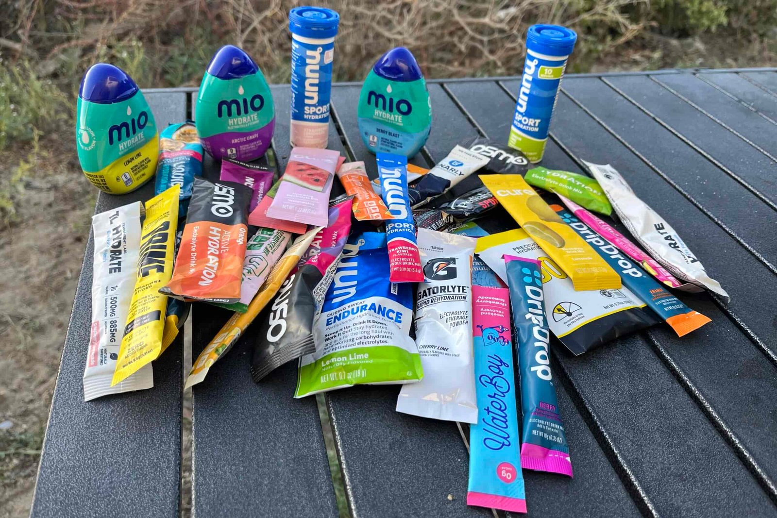 Semi-aerial view of dozens of electrolyte powders and mixes on a camping table